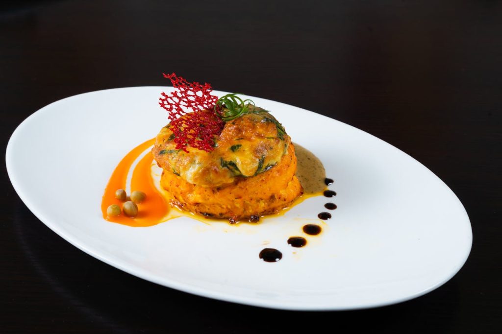 A white plate topped with a dish of food