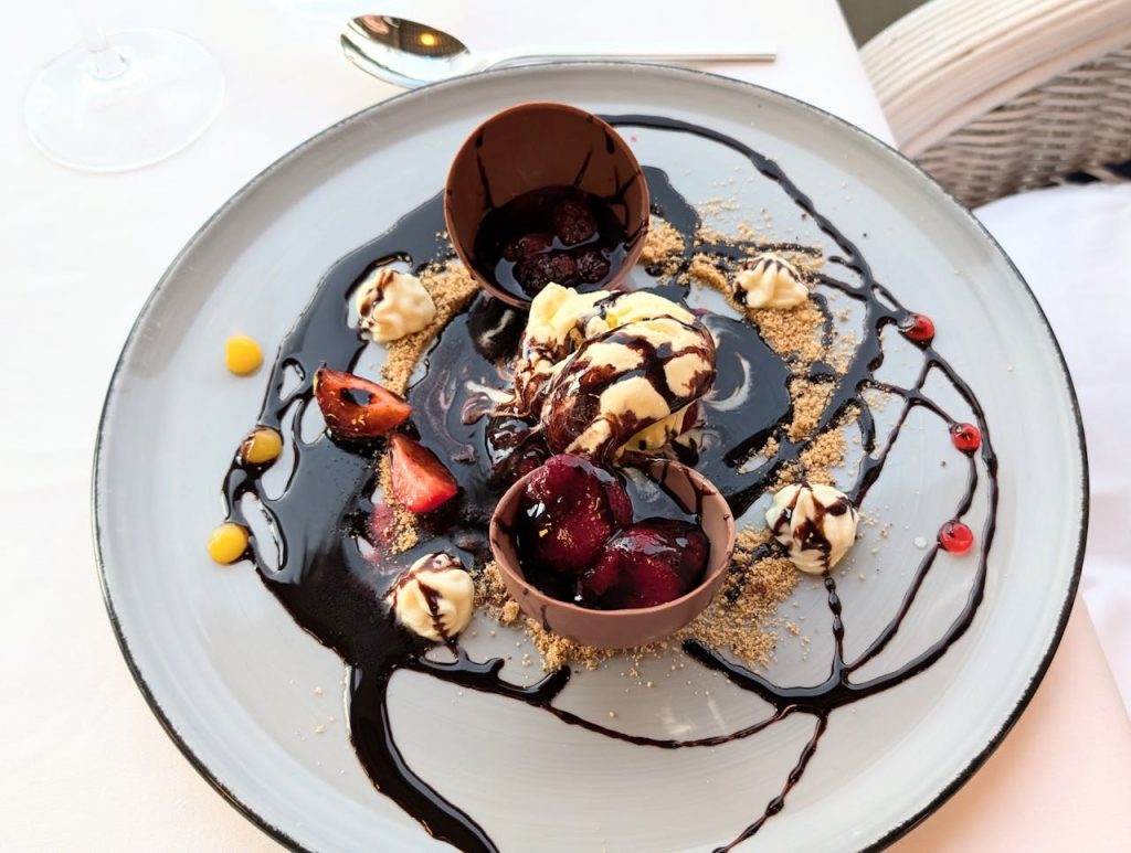 A dessert with chocolate sauce and fruit on a plate